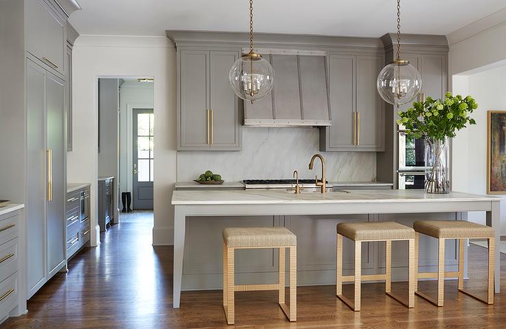 gray-shaker-kitchen-cabinets-long-brass-cabinet-pulls-gold-counter-stools
